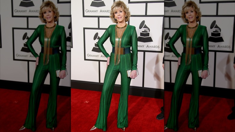 Jane Fonda posando en la alfombra roja de los Grammy luciendo un mono verde esmeralda con adornos dorados.