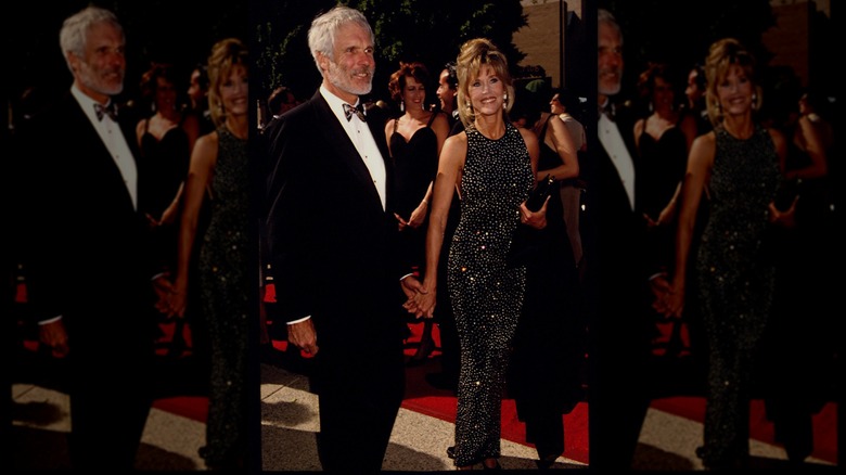 Jane Fonda en la alfombra roja de los premios Emmy luciendo un vestido largo negro con pedrería y cuello halter.