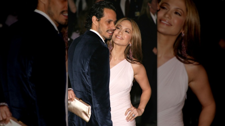 Jennifer López con un vestido rosa bebé, sonriendo a Marc Anthony con un traje de ante azul marino.