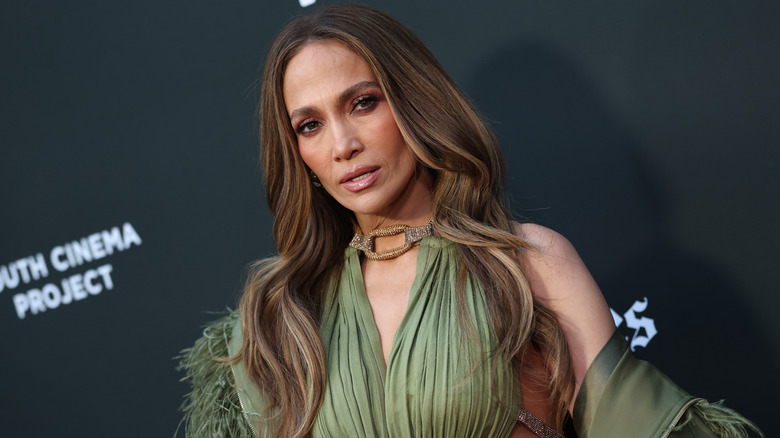 Jennifer López con vestido verde y cabello suelto