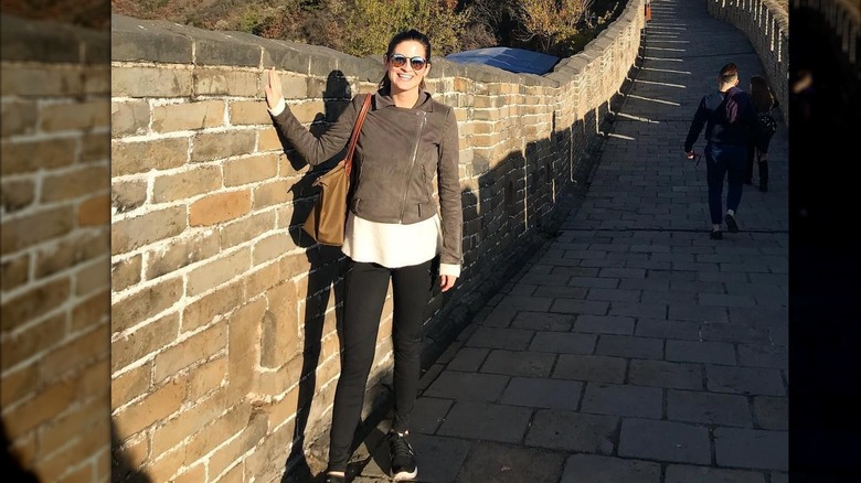Kaitlan Collins sonríe mientras posa visitando la Gran Muralla China (2017)