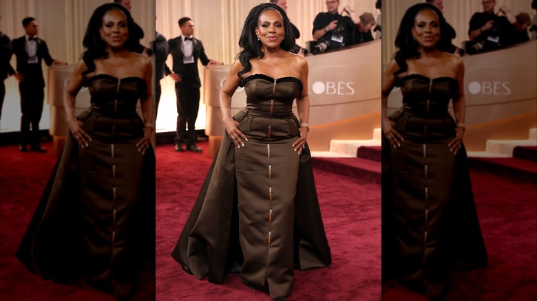 Sheryl Lee Ralph sonriendo en la alfombra roja luciendo un vestido palabra de honor color marrón chocolate con capa.