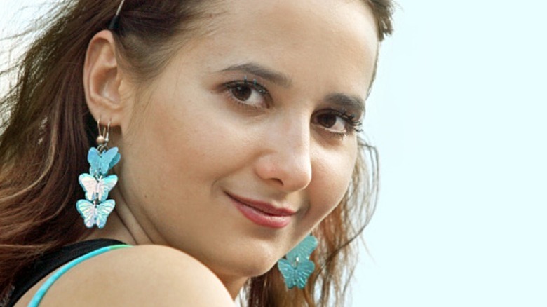 Una mujer con aretes de mariposa.