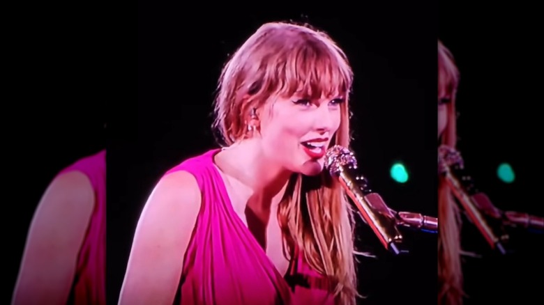 Taylor Swift tocando el piano y cantando durante el Eras Tour