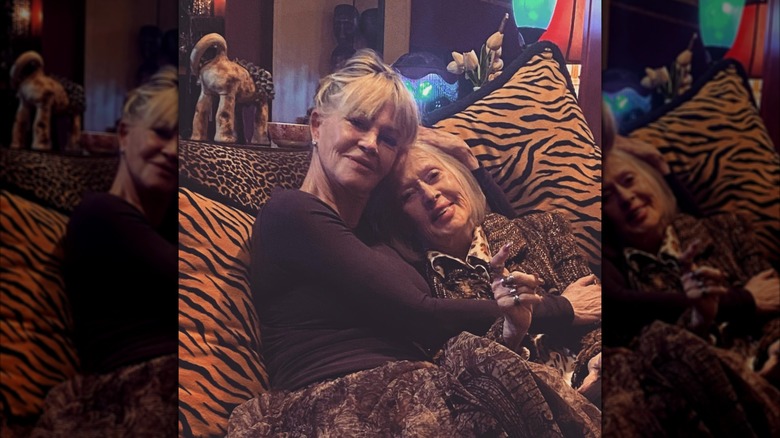 Melanie Griffith abraza a su madre Tippi Hedren mientras está sentada en un sofá con estampado animal