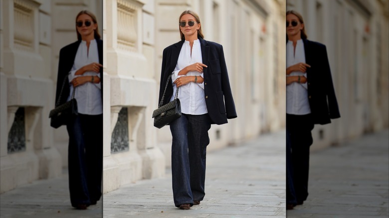 Una mujer con un par de jeans oscuros y una blusa blanca.