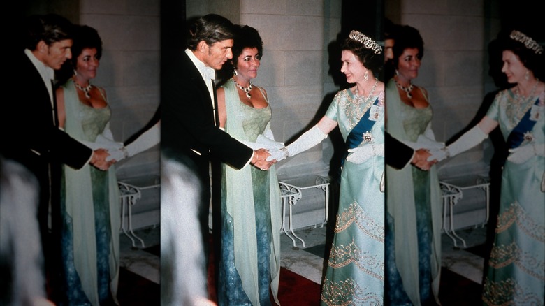 Elizabeth Taylor con un vestido verde con una bufanda y joyas llamativas se reunió con la reina Isabel con un vestido de colores similares.