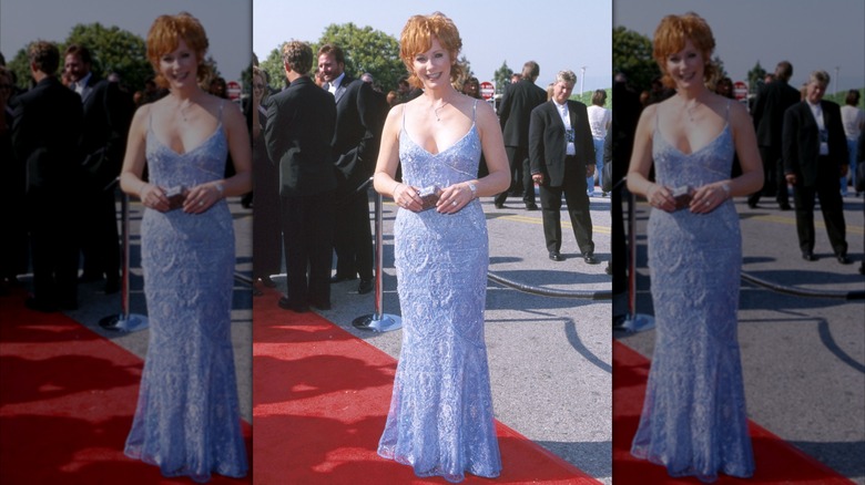 Reba McEntire posando en una alfombra roja con un vestido azul con tirantes finos en los Premios ACM 2000.