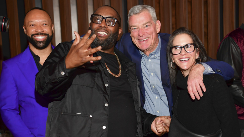Jami Gertz y Tony Ressler posando con Killer Mike y Paul Judge