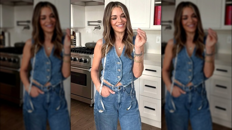 Sabrina Soto luciendo chaleco de mezclilla y jeans con una cinta métrica al cuello posa en una cocina.