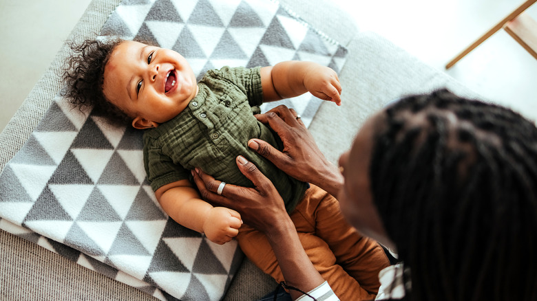 Una madre haciéndole cosquillas a su bebé que ríe