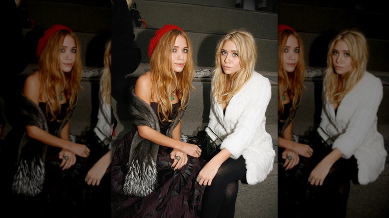 Mary Kate Olsen y Ashley Olsen fotografiadas en un desfile de moda con estilos independientes y sórdidos.
