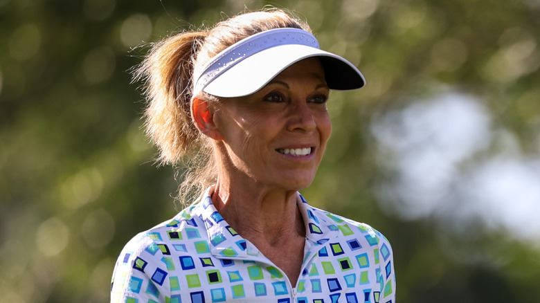 Vanna White con visera y polo mientras juega golf