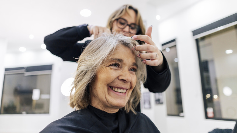 Una mujer tiene sus canas tratadas en un salón.
