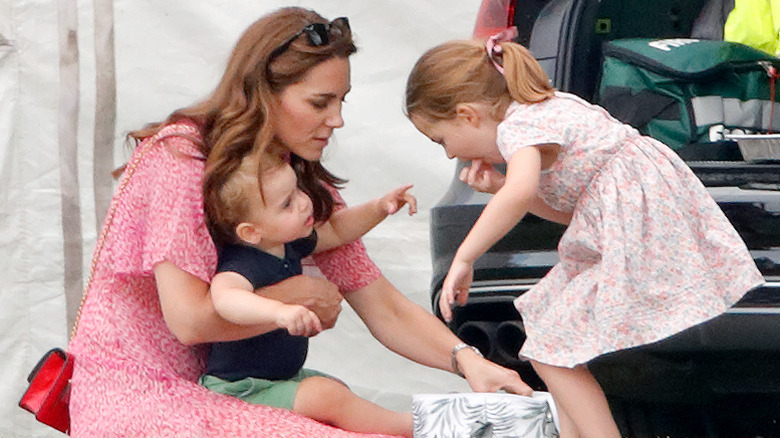 La princesa Charlotte toma un refrigerio de una hielera junto a su madre, Kate Middleton, y su hermano, el príncipe Louis.