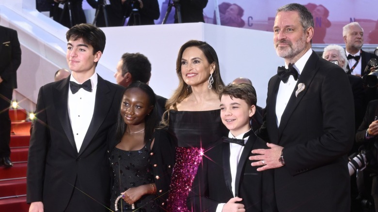 Mariska Hargitay posando en una alfombra roja con un vestido rojo brillante junto a sus hijos y su esposo.
