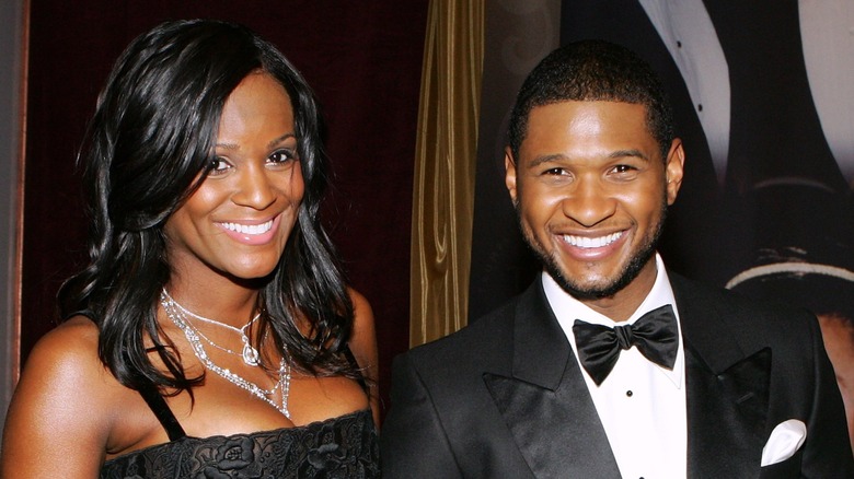 Lleve un esmoquin y Tameka Foster luce un vestido negro y joyas de diamantes en un evento.