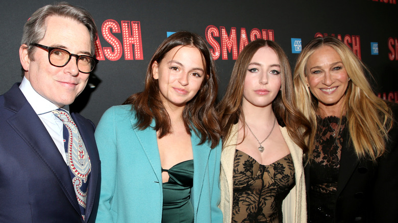 Matthew Broderick y Sarah Jessica Parker fotografiados sonriendo en un evento de alfombra roja con sus hijas Tabitha y Marion.