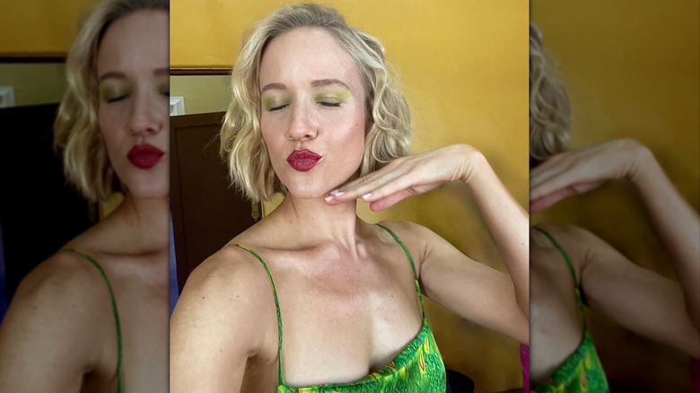 Jess Schram se toma una selfie en el set con sombra de ojos verde y los labios fruncidos