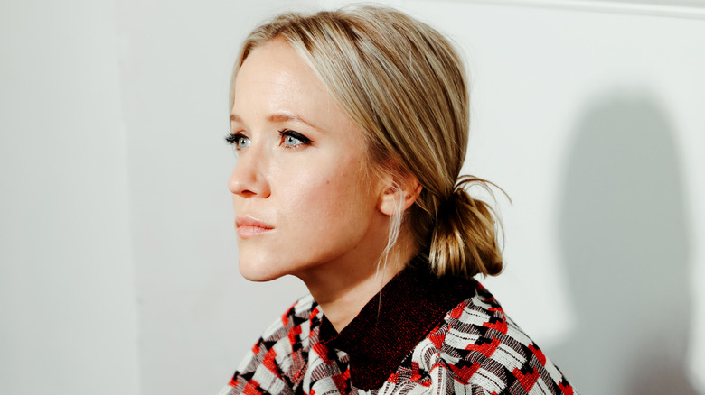 Jessy Schram sentada mirando al otro lado de la habitación