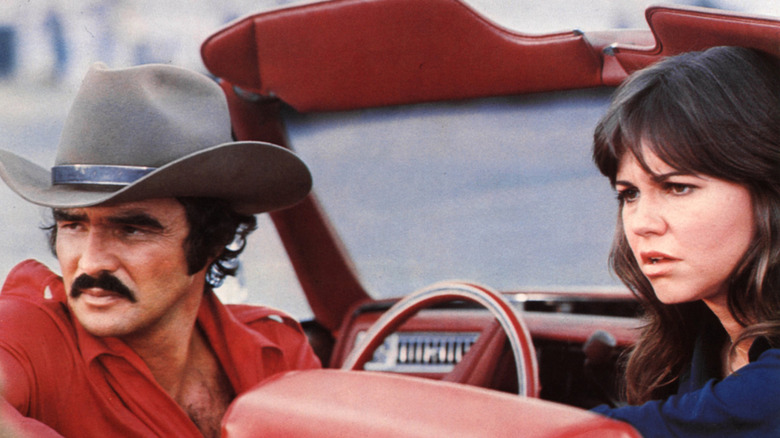 Burt Reynolds y Sally Field en una foto sentados en un descapotable en el set de 'Smokey and the Bandit'