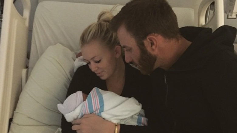 Dustin Johnson abraza a Paulina Gretzky mientras ella sostiene a su hijo recién nacido, Tatum Johnson, en el hospital.