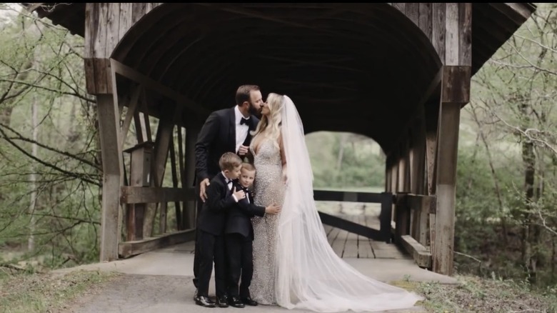 Dustin Johnson besa a Paulina Gretzky mientras sus dos hijos, Tatum y River Johnson, los abrazan el día de su boda.