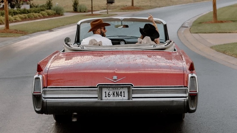 Dustin Johnson conduciendo a Paulina Johnson y sus hijos, Tatum y River Johnson, en un convertible.