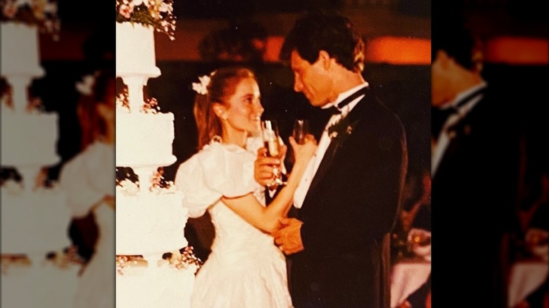 Maureen McCormick y Michael Cummings sostienen copas de champán el día de su boda