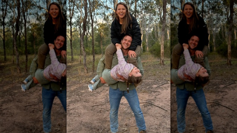 Chandler Powell sosteniendo a Bindi Irwin y su hija Grace