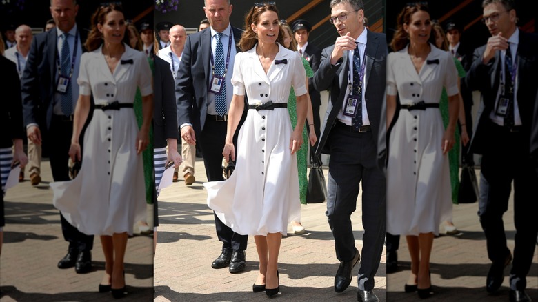 Kate Middleton con un vestido blanco con botones negros y cinturón negro en Wimbledon en 2019.