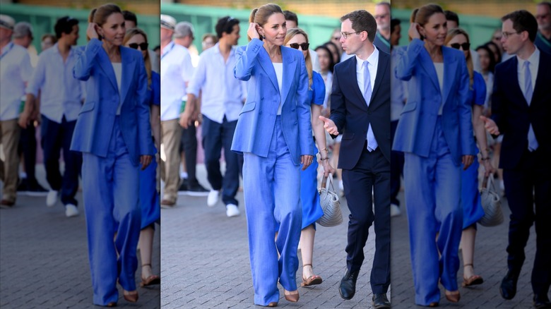 Kate Middleton con un traje holgado azul aciano con una camiseta blanca en Wimbledon en 2026.