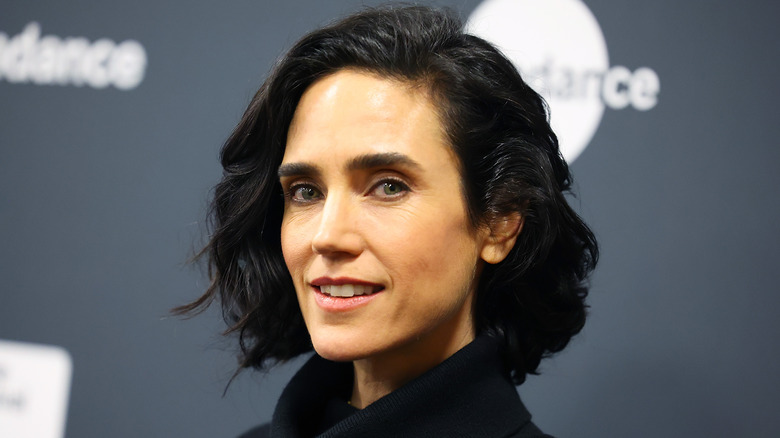 Jennifer Connelly sonríe con un jersey de cuello alto negro
