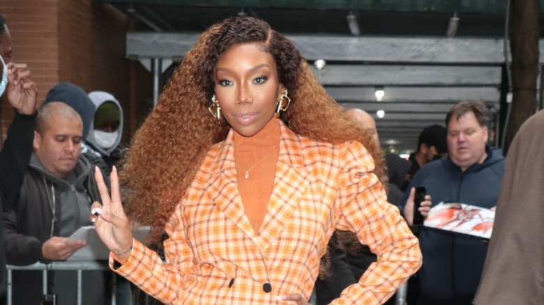 Brandy con una chaqueta a cuadros y un voluminoso cabello rizado