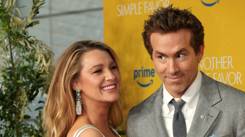Ryan Reynolds en la alfombra roja con una cara divertida junto a Blake Lively.