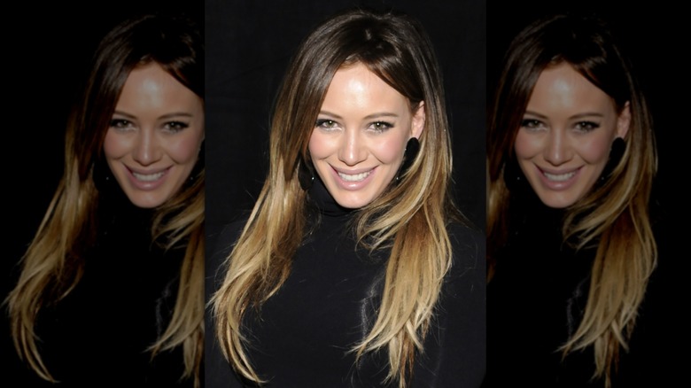 Hilary Duff sonriendo con un top negro en 2011