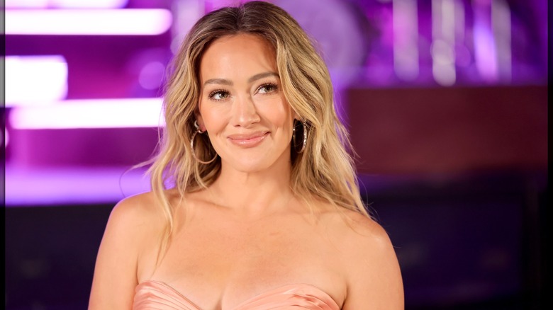 Hilary Duff sonriendo con raíces oscuras en 2026