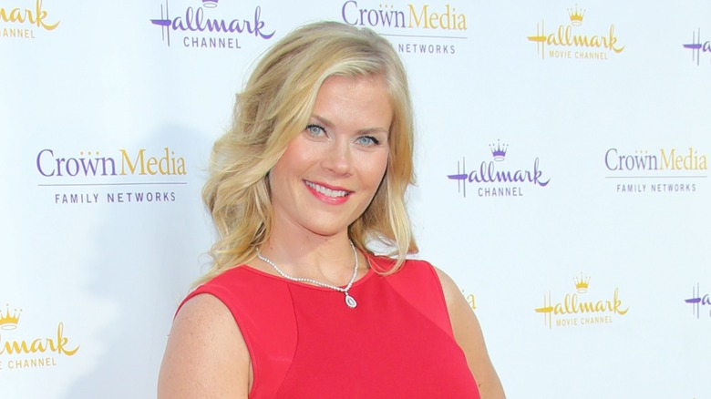 Alison Sweeney luce un vestido rojo y su cabello rubio suelto en ondas en la fiesta Summer TCA para Hallmark Channel en julio de 2014 en Beverly Hills, California.