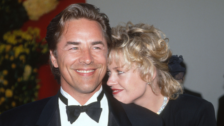 Don Johnson con esmoquin negro y Melanie Griffiths con vestido negro en un evento en 1989.