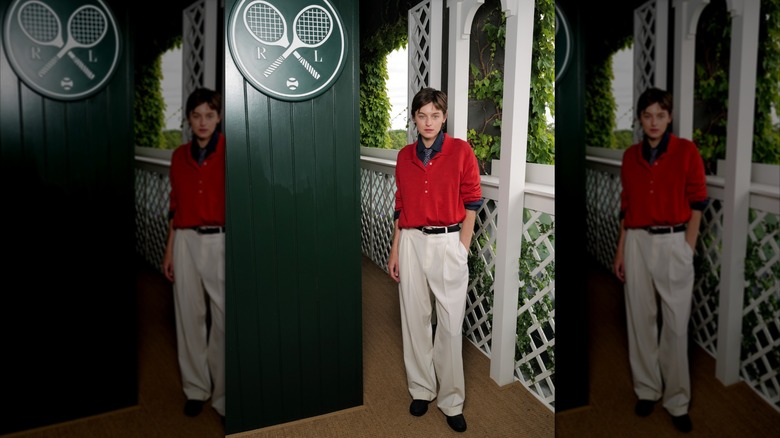Emma Corrin viste un polo holgado y corbata con pantalón de traje blanco para Wimbledon 2026