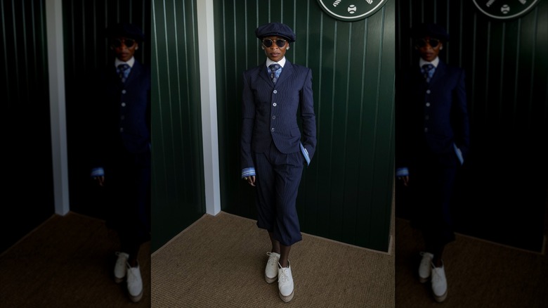 Cynthia Erivo luce traje de raya diplomática, corbata y gorra de vendedor de periódicos en Wimbledon 2026