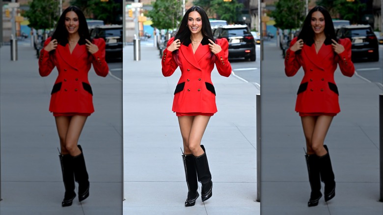 Kylie Cantrall luciendo un blazer rojo con hombreras y una minifalda.