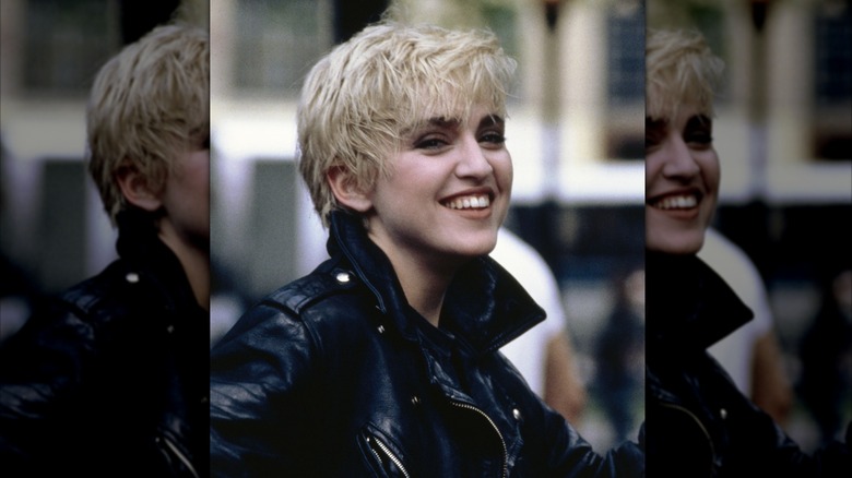 Madonna sonríe con una chaqueta de cuero negra.