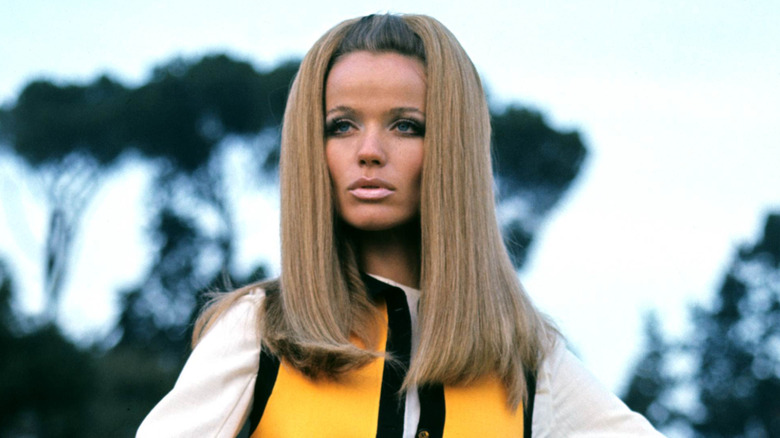 Veruschka posando con un top blanco y un chaleco amarillo