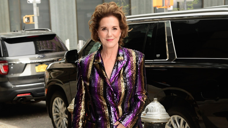 Elizabeth Perkins sonríe suavemente mientras está en la ciudad de Nueva York vistiendo un traje de lentejuelas brillantes.
