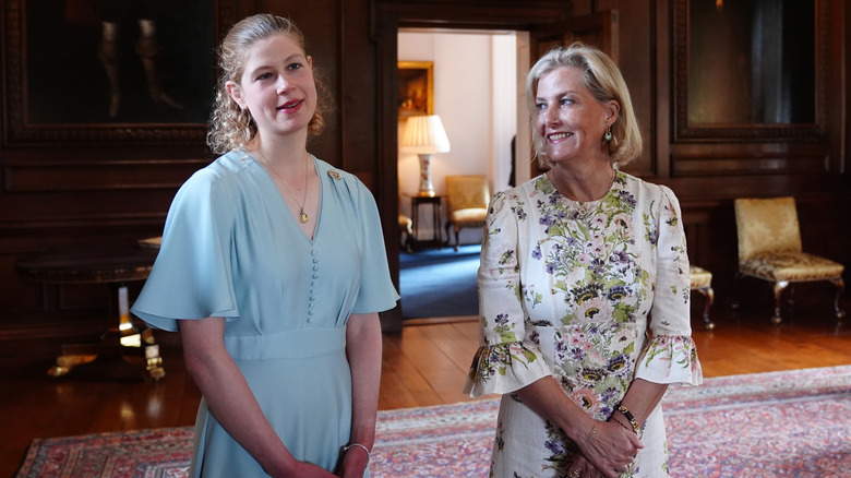 Lady Louise lleva un lóbulo rizado y un vestido azul en la foto con la duquesa Sophie con un vestido floral blanco.