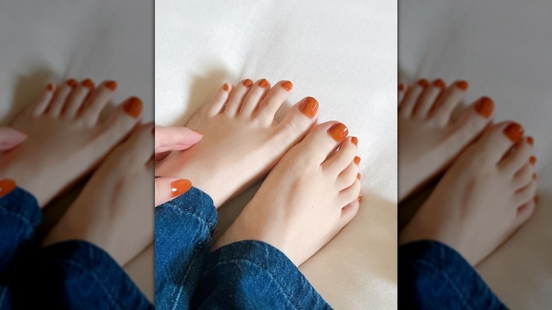 Cerca de una pedicura naranja quemada