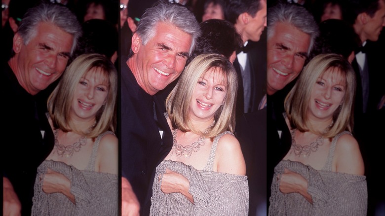 Barbra Streisand con un top brillante y un collar adornado posando con James Brolin en los Oscar de 1997.