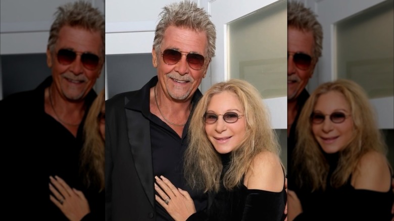 Una foto sincera de Barbra Streisand con un top negro y gafas de sol posando junto a su esposo James Brolin, también vestido de negro y gafas de sol.