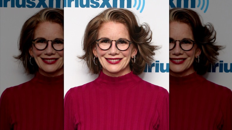 Melissa Gilbert sonríe luciendo un jersey de cuello alto rojo y gafas redondas